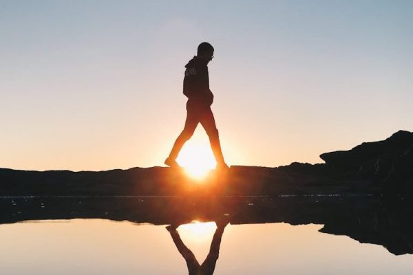 Silhouette of Man Walking Near the Ocean